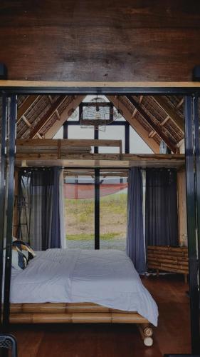 Cette chambre dispose d'un lit à baldaquin et d'une fenêtre. dans l'établissement Jairo's Nest, à Balasan