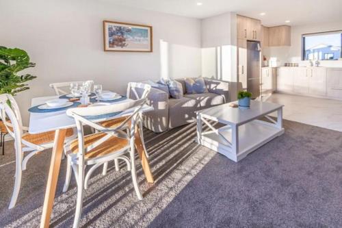 a living room with a table and a couch at Beach Front Abode- 2 Bed 2 Bath in Christchurch