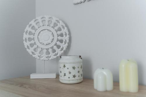 a table with two candles and a plate and two candles at Apartament Doris 2 - 50 m do plaży in Pobierowo