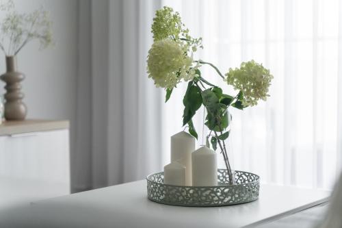 a vase with flowers in it on a table at Apartament Doris 2 - 50 m do plaży in Pobierowo
