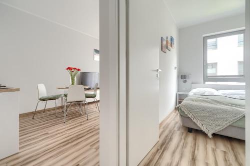 - une chambre blanche avec un lit et une table dans l'établissement Apartament Doris 2 - 50 m do plaży, à Pobierowo