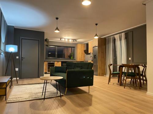 a living room with a green couch and a table at Best View Terrace in Târgu-Mureş