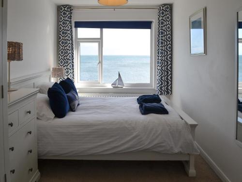 a bedroom with a bed and a window with the ocean at Craster View in Craster