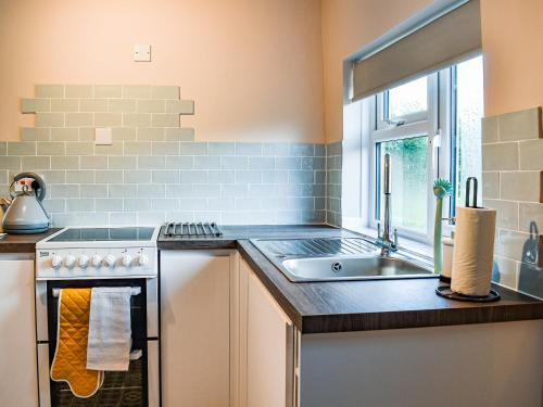 a kitchen with a sink and a stove at Brookdale in Malpas