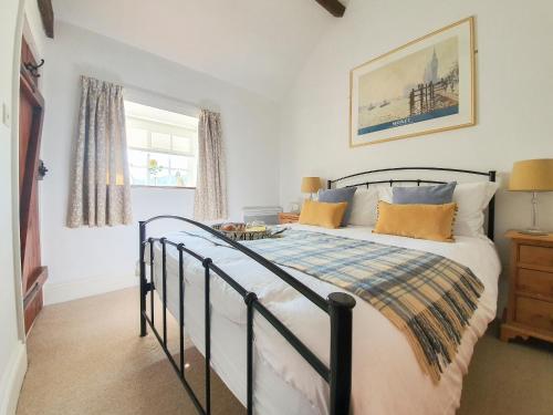 CloughtonにあるCurly Tail Cottageのベッドルーム1室(ベッド1台、テーブル、窓付)