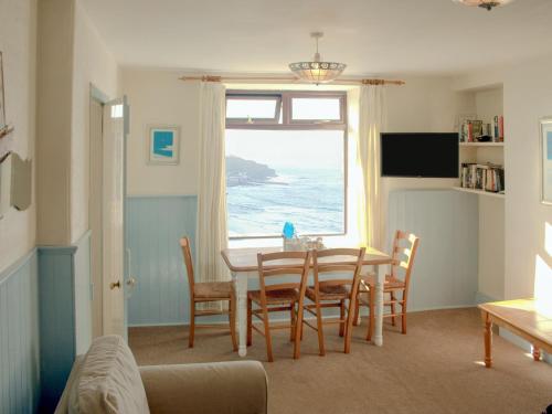 a dining room with a table and chairs and a window at Sevenstones in Trevilley