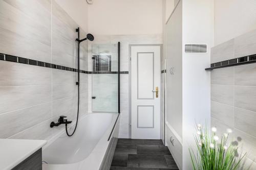 a white bathroom with a shower and a sink at Ferienwohnung am historischen Markt in Friedrichstadt