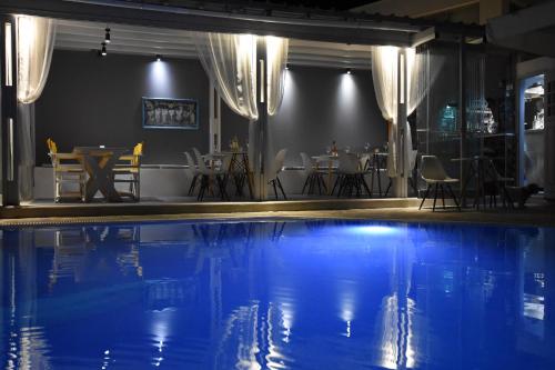 a swimming pool with a restaurant in the background at Rodakas Hotel in Akrotiri