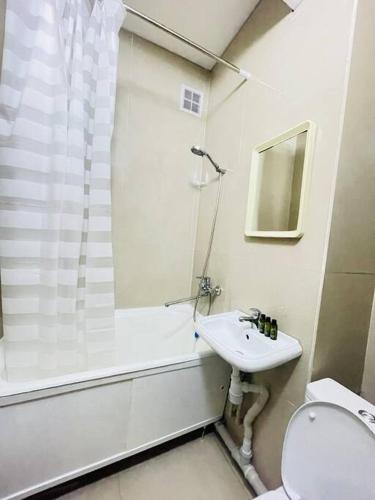 a bathroom with a sink and a shower and a toilet at Moon&Sun Apartments in Almaty