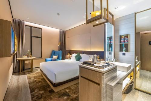 um quarto de hotel com uma cama e uma casa de banho em Echarm Plus Hotel - Ouzhuang Metro Station Branch em Guangzhou
