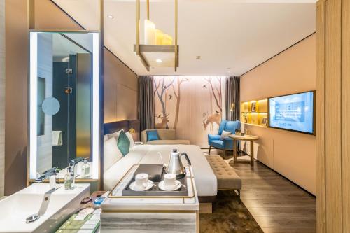 ein Hotelzimmer mit einem Bett und einem Waschbecken in der Unterkunft Echarm Plus Hotel - Ouzhuang Metro Station Branch in Guangzhou