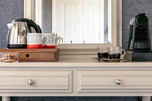a white dresser with a mirror on top of it at Craig Manor in Bowness-on-Windermere