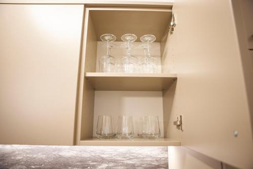 a cupboard with wine glasses sitting in it at Nove Boutique Apartments in Vienna