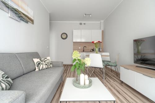 a living room with a couch and a table at Apartament Doris 2 - 50 m do plaży in Pobierowo