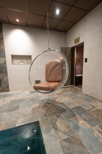 une chambre avec une chaise et une piscine dans l'établissement CARACALLA PRIVE - Chambres d'hôtes avec Piscine, Jaccuzi et Hammam privatifs, à Saint-Étienne
