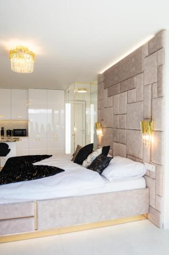 a bedroom with a large white bed with a stone wall at Penthouse apartments MINI s privátnou vírivou vaňou in Trstená