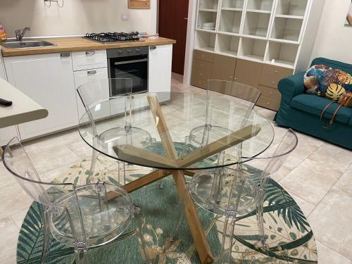 einen Glastisch und Stühle in der Küche in der Unterkunft La magia del mare in Sardegna (I.U.N. Q5901) in Iglesias