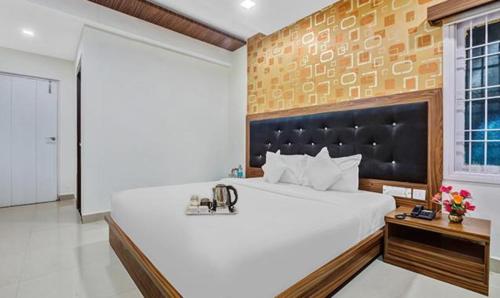 a bedroom with a large white bed and a window at FabHotel Luck Inn Residency in Chennai
