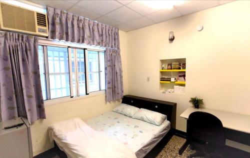 a dorm room with a bed and a window at 想來就來-台南包棟民宿-電動麻將ktv可寵物 in Tainan