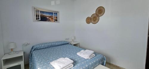 a small bedroom with a blue bed with towels on it at SOL Y PLAYA in San Fernando