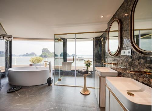 a bathroom with a tub and a sink and a mirror at Sea Stars Cruise Ha Long Bay in Ha Long