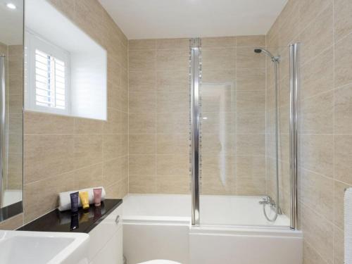 y baño con ducha y bañera blanca. en Property 2 en Wroxall