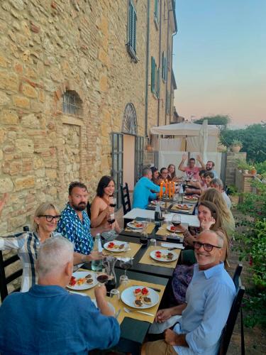 a group of people sitting at tables eating food at Casa Cerboneschi in Casale Marittimo
