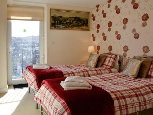 two beds in a room with a window at Apartment 6 in Ilfracombe