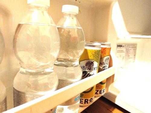 einen Kühlschrank mit 2 Flaschen Bier und anderen Getränken in der Unterkunft Al Quadrato D'Oro rooms in Catania
