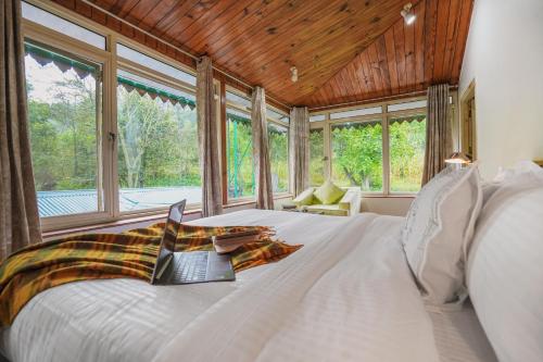 una camera da letto con un letto con un computer portatile sopra di SaffronStays Kasauli Estate a Kasauli
