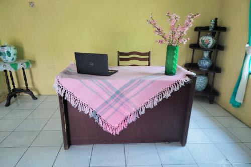 a table with a pink table cloth and a laptop on it at SPOT ON 93104 Barak Tambunan in Medan