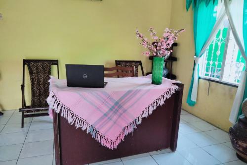 a table with a pink table cloth and a laptop on it at Hotel O Barak Tambunan NearBelawan Port in Medan