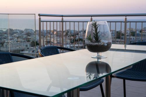 een tafel met een plant in een wijnglas op een balkon bij EDEL Suite in Chania