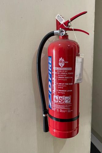 a red fire hydrant is attached to a wall at Hotel O Barak Tambunan NearBelawan Port in Medan