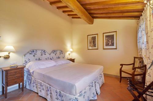 a bedroom with a bed and a wooden ceiling at Tenuta di Artimino member of Meliá Collection Wine Resort in Artimino
