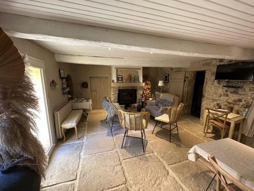 sala de estar con sillas y chimenea de piedra en Le Mas du Père Jean, en Roche-Saint-Secret