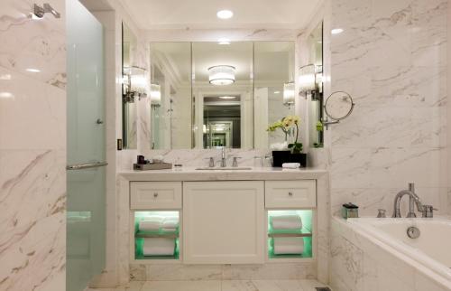 a bathroom with a sink and a tub and a mirror at The Ritz-Carlton, Kuala Lumpur - TravelEase Visa-Free Getaway in Kuala Lumpur
