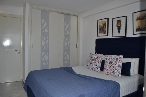 a bedroom with a bed with blue sheets and pillows at AiM HOUSE in Marrakech