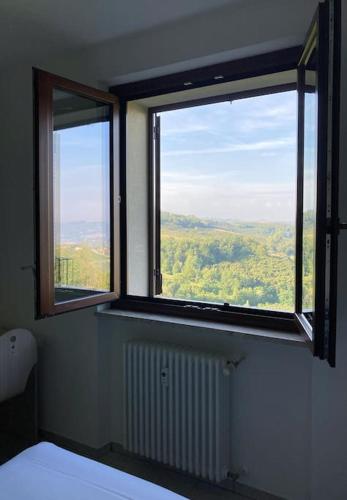 a room with two windows with a view of the countryside at Wolf Apartment - Apartment in Langhe in Montelupo Albese
