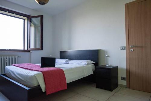 a bedroom with a bed with a laptop on it at Wolf Apartment - Apartment in Langhe in Montelupo Albese