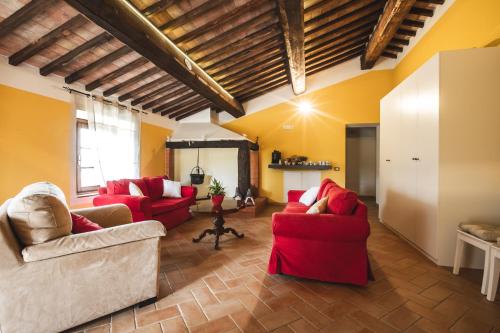 una sala de estar con muebles rojos y paredes amarillas. en Masseria del Bosco - Podere Poderuccio, en Chianciano Terme