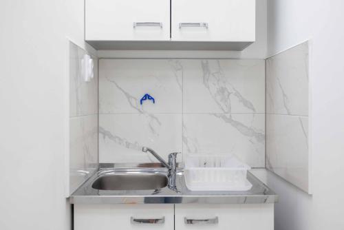 a kitchen with a sink and a counter top at The Sun Apartments Brcko in Brčko