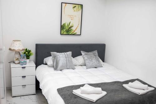 1 dormitorio con 1 cama blanca grande y toallas. en The Sun Apartments Brcko en Brčko