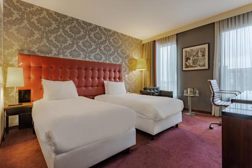 pokój hotelowy z 2 łóżkami i czerwonym zagłówkiem w obiekcie Crowne Plaza Amsterdam - South, an IHG Hotel w Amsterdamie