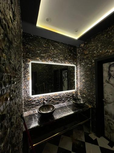 a stone bathroom with a sink and a mirror at Villa Vista in Islamabad