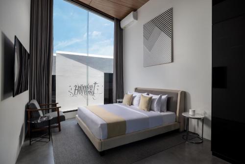 ein Schlafzimmer mit einem Bett und einem großen Fenster in der Unterkunft Alex Villas Complex N2 in Canggu