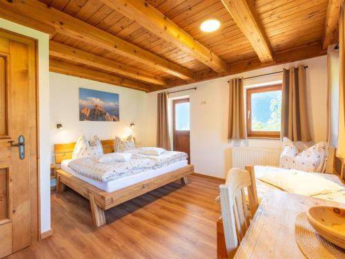 a bedroom with two beds and a table at beautifully renovated farmhouse Stoanerbauer with a wonderful view in Dorf