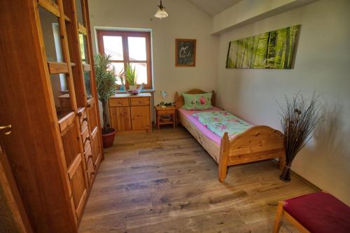 een slaapkamer met een bed en een houten vloer bij Ferienwohnung-auf-dem-Bauernhof-fuer-4-oder-5-Personen-im-Herzen-Niederbayerns in Mamming