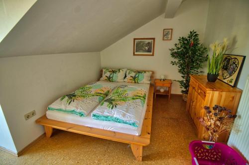 een slaapkamer met een bed en een houten dressoir bij Ferienwohnung-auf-dem-Bauernhof-fuer-4-oder-5-Personen-im-Herzen-Niederbayerns in Mamming