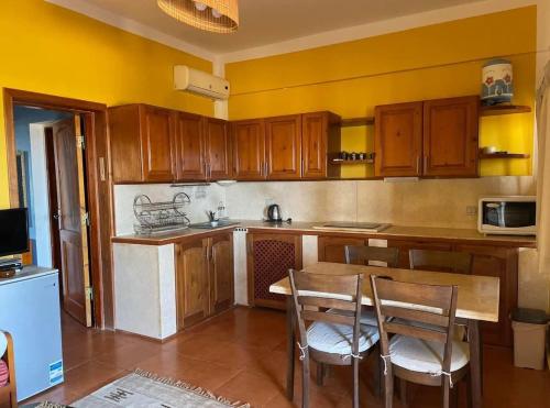 a kitchen with wooden cabinets and a table and chairs at Sea View apartment in Dahab